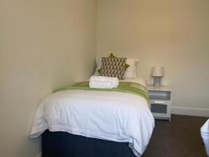 1 dormitorio pequeño con 1 cama con sábanas blancas en Gladstone Apartments by Bluebell Rooms, en Southampton