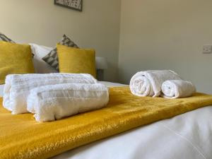 two towels sitting on top of a bed at Gladstone Apartments by Bluebell Rooms in Southampton