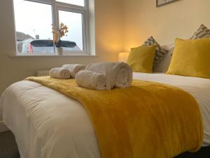 1 Schlafzimmer mit 2 Handtüchern auf einem Bett mit Fenster in der Unterkunft Gladstone Apartments by Bluebell Rooms in Southampton