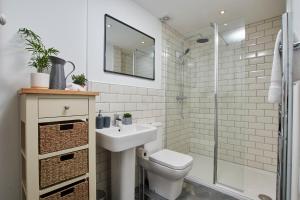 a bathroom with a toilet and a sink and a shower at Delven House, Apartment 3 in Castle Donington