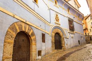 an old building with two doors and a street at Casa Jarreta Azagra Albarracin in Albarracín