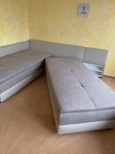 two beds in a room with a clock on the wall at Ferienwohnung "Herzenslust" in Braunlage +5 photos