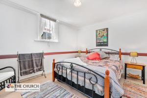 um quarto com uma cama com uma almofada vermelha em 'THE CHURCH' Guest Home, Gawler Barossa Region em Willaston