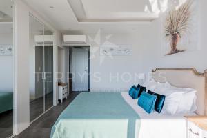 a bedroom with a large bed with blue pillows at ADRIANA by Terry's Homes WATERFRONT SEAVIEW BEACH in Cannes