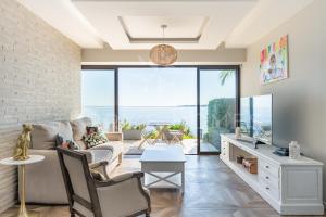 a living room with a couch and a tv at ADRIANA by Terry's Homes WATERFRONT SEAVIEW BEACH in Cannes