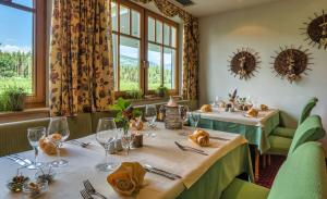 - une salle à manger avec deux tables et des fenêtres dans l'établissement Hotel Flötscherhof, à Naz-Sciaves