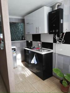 uma cozinha com armários brancos e um lavatório em Bella Apartment em Tbilisi