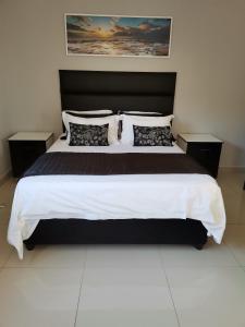 a bedroom with a large bed with a black headboard at Condo Villas in Durban
