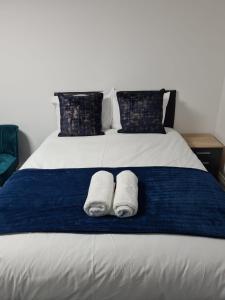 a bed with two white towels on a blue blanket at Wns Hotel Canary Wharf in London