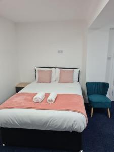 a bedroom with a bed and a blue chair at WNS Apartments Canary Wharf in London