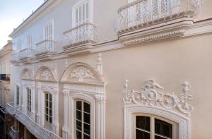 a white building with a balcony on the side of it at Áurea Casa Palacio Sagasta by Eurostars Hotel Company in Cádiz