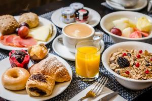 a table topped with plates of breakfast foods and orange juice at Áurea Casa Palacio Sagasta by Eurostars Hotel Company in Cádiz