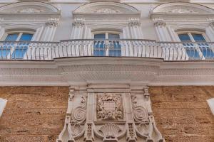 a building with a balcony with a statue on it at Áurea Casa Palacio Sagasta by Eurostars Hotel Company in Cádiz