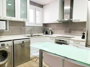 エスカルデス・エンゴルダニにあるApartamento Perfección al lado de Caldeaの白いキャビネット、シンク、食器洗い機付きのキッチンが備わります。