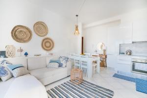 een woonkamer met een witte bank en een tafel bij La Terrazza Poetto 2 passi dalla Spiaggia in Cagliari