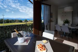 un tavolo con una bottiglia di vino e cibo sul balcone di APARTMENT BLANCO - Regarda Travel a Lazise