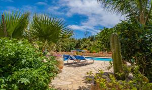 uma piscina com mesa, cadeiras e plantas em Villa Le Rasce em Leuca
