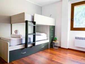 una camera con 2 letti a castello e un pavimento in legno di Apartamento moderno Perafita, con vistas en Arinsal a Mas de Ribafeta