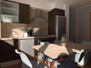 a kitchen with a wooden table and chairs at Apartamento moderno Coma Pedrosa con vista en Arinsal in Arinsal