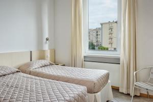 Cette chambre comprend 2 lits et une fenêtre. dans l'établissement Affittacamere de’ Cappuccini, à Empoli