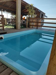 a pool on the deck of a house at Pousada Marambaia Café - Praiana, econômica, Com café da manhã, piscina e hidromassagem ao ar livre - Frente para o mar in Barra de Guaratiba