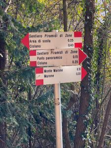 a street sign with arrows pointing in different directions at Ostello Trentapassi in Zone