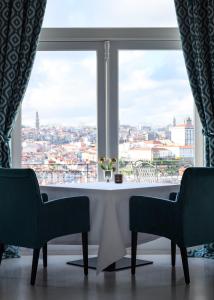 a table and two chairs in front of a window at The Yeatman in Vila Nova de Gaia