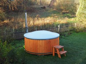 a hot tub and a stool in a yard at Agroturystyka Gęsiniec Stare Osieczno in Stare Osieczno