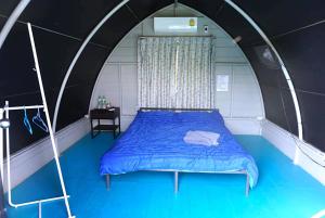 a bedroom with a blue bed in a tunnel at Feel like home แบบบ้านบ้าน in Talat Amphoe Nakhon Chai Si
