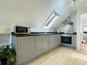 a kitchen with a sink and a microwave oven at Silverwood Coach House in Frome