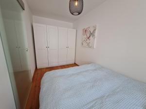 - une chambre avec un lit et des murs blancs dans l'établissement Wohnung Fleethörn - zentral, ruhig, mit Parkplatz und Balkon, à Kiel