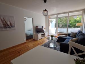 a living room with a couch and a tv at Wohnung Fleethörn - zentral, ruhig, mit Parkplatz und Balkon in Kiel