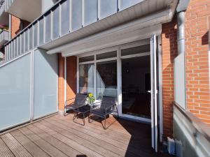 a patio with two chairs and a table on a balcony at Wohnung Fleethörn - zentral, ruhig, mit Parkplatz und Balkon in Kiel