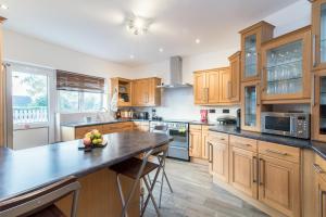 uma cozinha com armários de madeira e uma mesa com frutas em Mountsorrel House - Spacious 5bed in Leicester Ideal for Families and Contractors em Mountsorrel