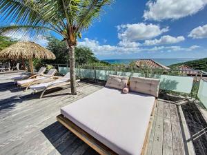 a patio with lounge chairs and a view of the ocean at Villa Zen, luxury and confort, private pool and sea view in Cul de Sac