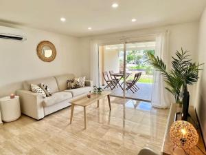 uma sala de estar com um sofá e uma mesa em Maracuja 4, Orient Bay village, walkable beach at 100m em Orient Bay