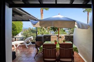 卡門港的住宿－Chalet Nº 7 Tajinaste，一个带桌子和遮阳伞的庭院