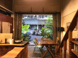 a dining room with a table and a view of a courtyard at Boundary Hostel and Cafe in Suratthani