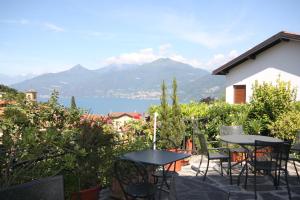 a patio with tables and chairs and a view of the water at Balcone Fiorito in Menaggio