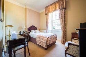 a bedroom with a bed and a desk and a window at Judges Hotel in Yarm