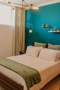 a bedroom with a large bed with a blue wall at Lescalier Cabanas 511 in Amanzimtoti
