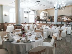 a banquet hall with white tables and chairs and chandeliers at Hotel Florida in Albacete