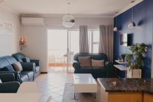 a living room with blue chairs and a couch at Lescalier Cabanas 511 in Amanzimtoti