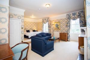 a bedroom with a bed and a blue couch at Judges Hotel in Yarm