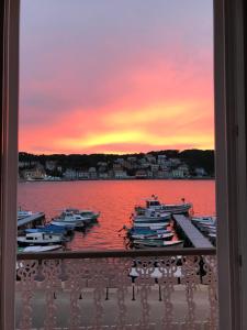 a group of boats docked at a dock with a sunset at Vindobona in Mali Lošinj