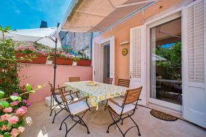 einen Tisch mit Stühlen und einem Sonnenschirm auf einer Terrasse in der Unterkunft Vindobona in Mali Lošinj