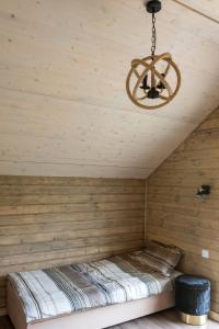 a bed in a wooden room with a chandelier at Kruszkanawierzbie in Kruszka