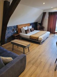 een hotelkamer met een bed en een bank bij Les chambres de la Cotinière - Bord de Saône - St Jean de Losne in Saint-Jean-de-Losne