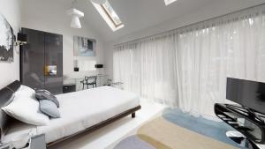 a bedroom with a bed and a large window at South Lodge in Milton Keynes