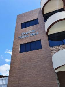 a building with a sign on the side of it at Pousada Nilza Mar in Maceió